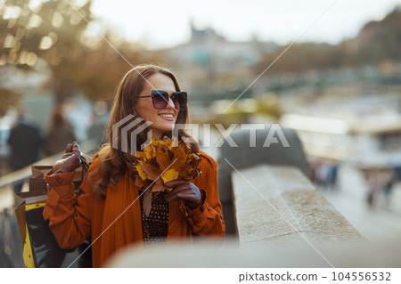 smiling elegant woman in brown trench coat 104556532