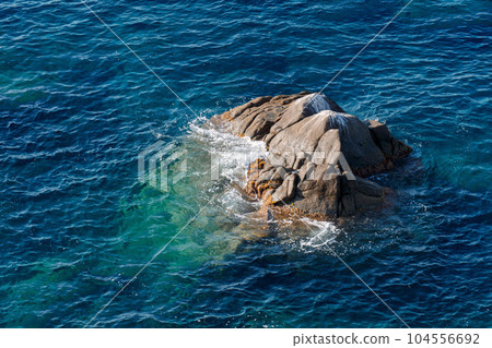 Waves on rocky beach, sea shore with waves crushing over the big rocks Waves on rocky beach, sea shore with waves crushing over the big rocks 104556692