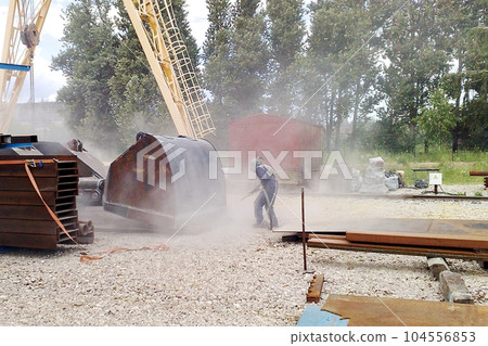 Sandblasting process. Cleaning the metal construction surface from rust before painting. Anticorrosive metal protection. 104556853