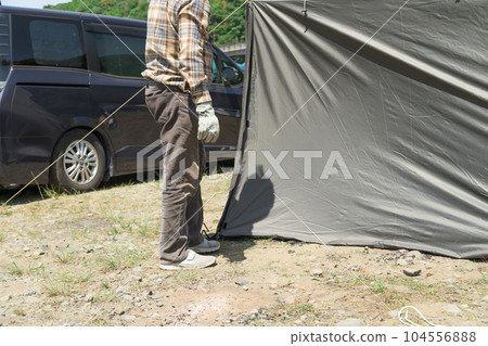 [Auto camping on the Nakatsugawa riverbed, removing the pegs from the tent skirt and preparing to withdraw] 104556888
