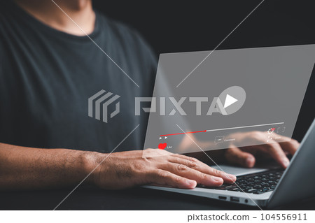 Businessman captivated by an online live stream on his laptop. Video streaming concept with a multimedia player on the screen. Embracing the power of technology for media consumption. Businessman captivated by an online live stream on his laptop. Video streaming concept with a multimedia player on the screen. Embracing the power of technology for media consumption. 104556911