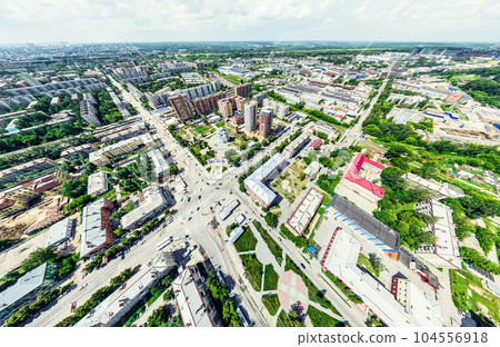 Aerial city view with crossroads and roads, houses, buildings, parks and parking lots. Sunny summer panoramic image 104556918