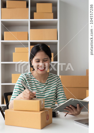 Successful SME entrepreneur. Asian woman working on receipt box and check online orders. business sme concept 104557286