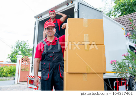 Portrait of delivery man stand near stack of boxes and look at camera with smiling and his co-worker Portrait of delivery man stand near stack of boxes and look at camera with smiling and his co-worker 104557401
