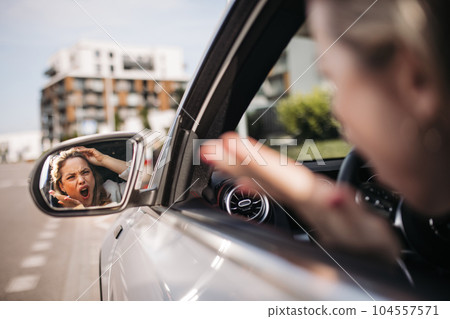 Nervous woman driving her car in city, shoutng at somebody. 104557571