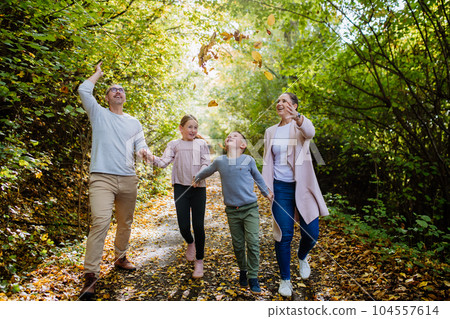 Excited family with kids walking in autumn forest. 104557614