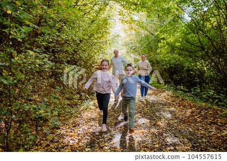 Happy family with kids running in forest. 104557615