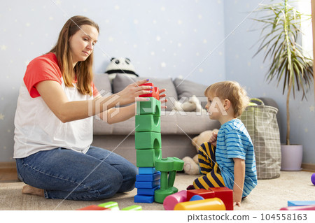 Happy loving family plays with plastic blocks and have fun. Happy loving family plays with plastic blocks and have fun. 104558163