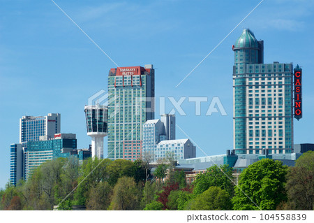 NIAGARA FALLS, ONTARIO, CANADA - MAY 21st 2018: Exterior view of the Fallsview Casino Resort tower and skyline in Niagara Falls during spring NIAGARA FALLS, ONTARIO, CANADA - MAY 21st 2018: Exterior view of the Fallsview Casino Resort tower and skyline in Niagara Falls during spring 104558839