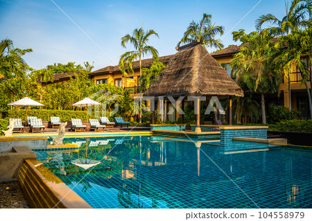 Beachfront sunrise with pool and palm trees in Hua Hin, Prachuap Khiri Khan, Thailand Beachfront sunrise with pool and palm trees in Hua Hin, Prachuap Khiri Khan, Thailand 104558979