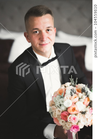 Grooms morning preparation. Handsome man getting dressed and preparing for the wedding 104559810
