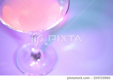 A glass of drink in pink and blue lighting. A glass of drink in pink and blue lighting. 104559960