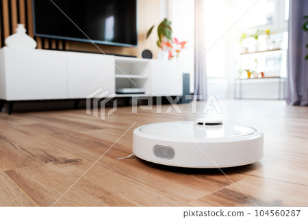 White robot vaccum cleaner in the living room 104560287