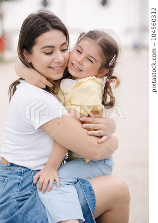 Cute girl hug her mom and have fun. Female with daughter outdoor 104560312