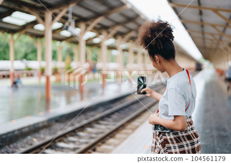 Tourists african american are showing happy expressions while waiting for their journey in the train station 104561179