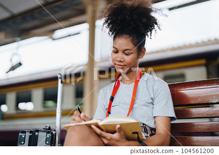 Tourists african american are showing happy expressions while waiting for their journey in the train station Tourists african american are showing happy expressions while waiting for their journey in the train station 104561200