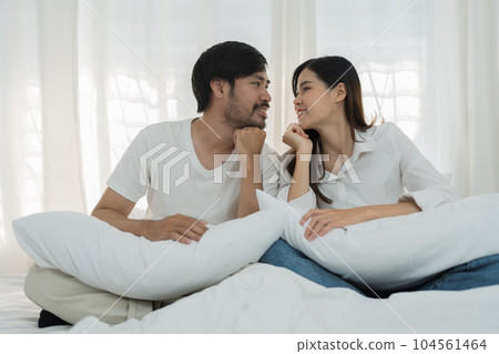 Asian Romantic couple in bed enjoying sensual foreplay Happy sensual young couple lying in bed together. Beautiful loving couple kissing in bed Asian Romantic couple in bed enjoying sensual foreplay Happy sensual young couple lying in bed together. Beautiful loving couple kissing in bed 104561464