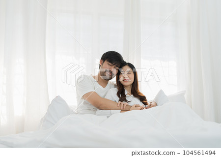 Asian Romantic couple in bed enjoying sensual foreplay Happy sensual young couple lying in bed together. Beautiful loving couple kissing in bed Asian Romantic couple in bed enjoying sensual foreplay Happy sensual young couple lying in bed together. Beautiful loving couple kissing in bed 104561494