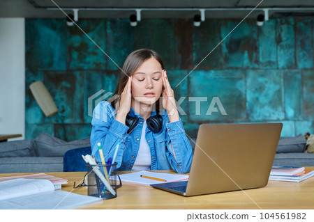Unhappy sad female university student at home at her desk 104561982