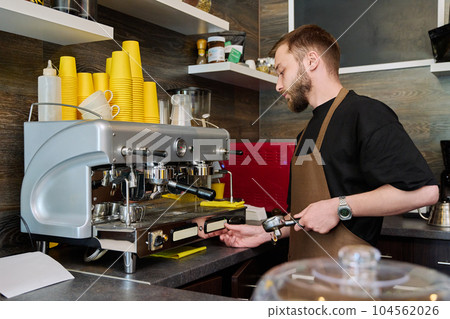 Young male barista preparing coffee in coffee shop Young male barista preparing coffee in coffee shop 104562026