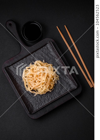 Delicious dried squid in the form of shavings with salt and spices Delicious dried squid in the form of shavings with salt and spices 104562523