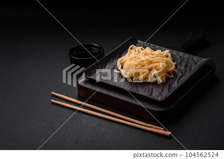 Delicious dried squid in the form of shavings with salt and spices Delicious dried squid in the form of shavings with salt and spices 104562524