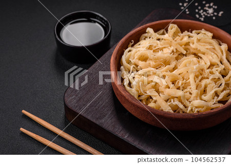 Delicious dried squid in the form of shavings with salt and spices Delicious dried squid in the form of shavings with salt and spices 104562537