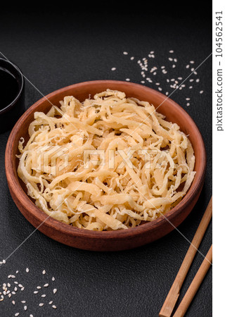 Delicious dried squid in the form of shavings with salt and spices Delicious dried squid in the form of shavings with salt and spices 104562541