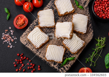 Delicious salty rectangular wheat croutons with cream cheese, tomatoes, salt and spices 104562603