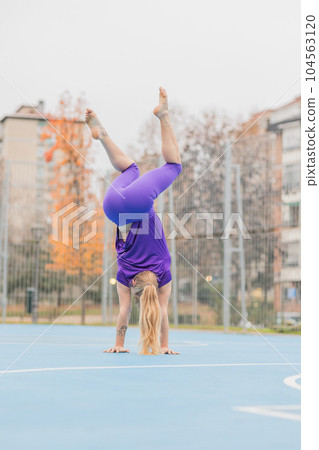 Sport fitness handstand exercise for calisthenics balance. Hispanic mid adult woman workout 104563120