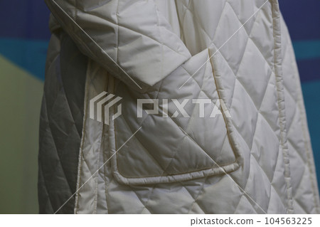 Close-up fragment of a white waterproof raincoat with a sleeve and a pocket. Close-up fragment of a white waterproof raincoat with a sleeve and a pocket. 104563225