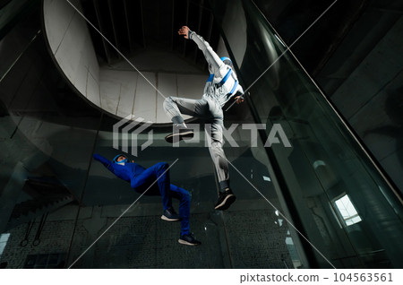 A man and a woman enjoy flying together in a wind tunnel. Free fall simulator 104563561