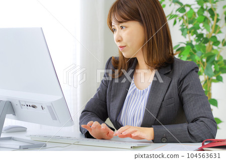 A young woman who works hard at her desk A young woman who works hard at her desk 104563631