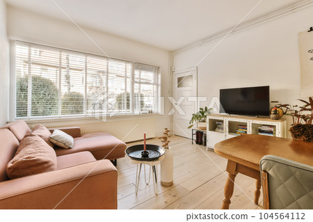 a living room with a couch, coffee table, and television on the wall in the room is bright white 104564112