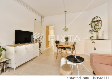 a living room with white brick walls and wood flooring in the center of the room is a pink sofa 104564115