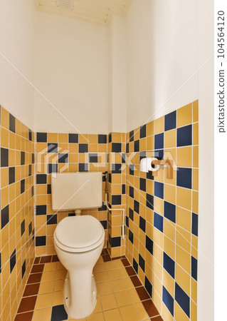 a bathroom with yellow and blue tiles on the walls, white toilet bowl in the corner is next to the sink a bathroom with yellow and blue tiles on the walls, white toilet bowl in the corner is next to the sink 104564120