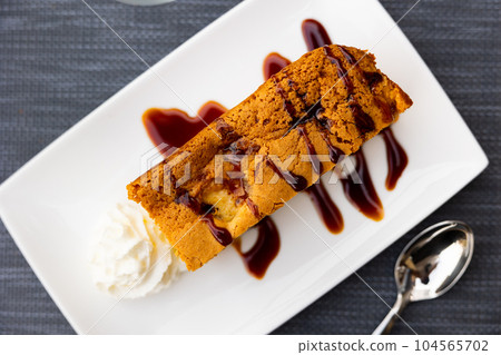 Rectangular piece of lush apple pie with delicate crispy crust and sprinkled with cherry syrup Rectangular piece of lush apple pie with delicate crispy crust and sprinkled with cherry syrup 104565702