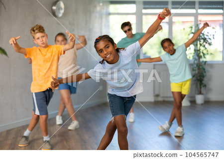 African boy perform choreographic exercises and teach energetic social dance waacking with friends 104565747