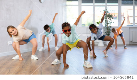 African girl in sun glasses perform exercise and teach social dance Jazz-modern with friends 104565941