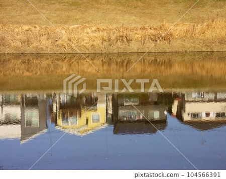 View of the reservoir in winter reflecting the houses on the opposite bank View of the reservoir in winter reflecting the houses on the opposite bank 104566391