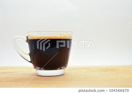 glass of hot black coffee put on wood background glass of hot black coffee put on wood background 104566870