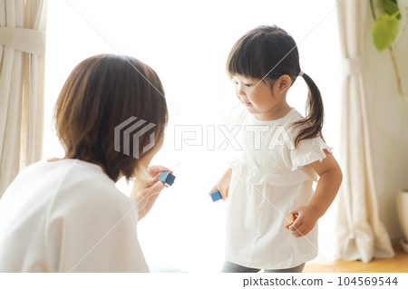 Photo of parent and child playing in the living room 104569544