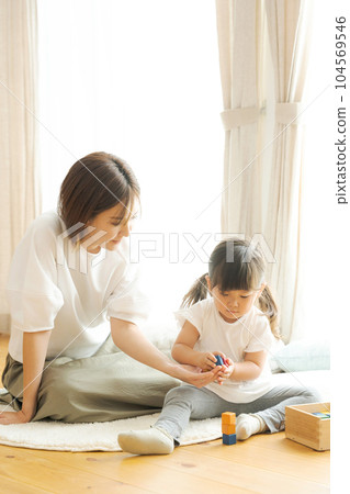 Photo of parent and child playing in the living room 104569546