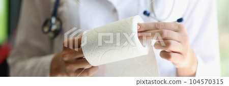 Female doctor hands demonstrates toilet paper roll Female doctor hands demonstrates toilet paper roll 104570315
