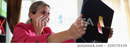 Angry and stressful woman shaking pc screen Angry and stressful woman shaking pc screen 104570339