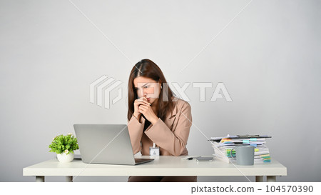Tired Asian businesswoman feeling stressed and upset about her work Tired Asian businesswoman feeling stressed and upset about her work 104570390