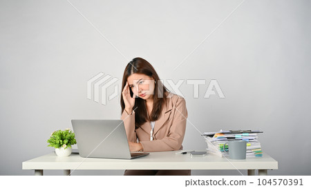 Tired Asian businesswoman feeling stressed and upset about her work Tired Asian businesswoman feeling stressed and upset about her work 104570391