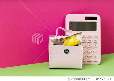 Yellow rocket on desk in pink briefcase with calculator on magenta background. copy space for back to school education and creativity concept. Cost of Success ideas. STEM or small business 104574274