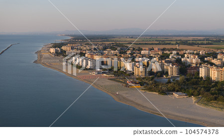aerial shot of sandy beach with umbrellas and town background aerial shot of sandy beach with umbrellas and town background 104574378