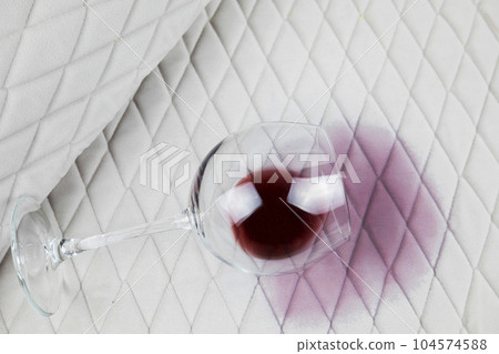 a spilled glass of wine on the tablecloth. Cleaning clothes and furniture from stains. 104574588